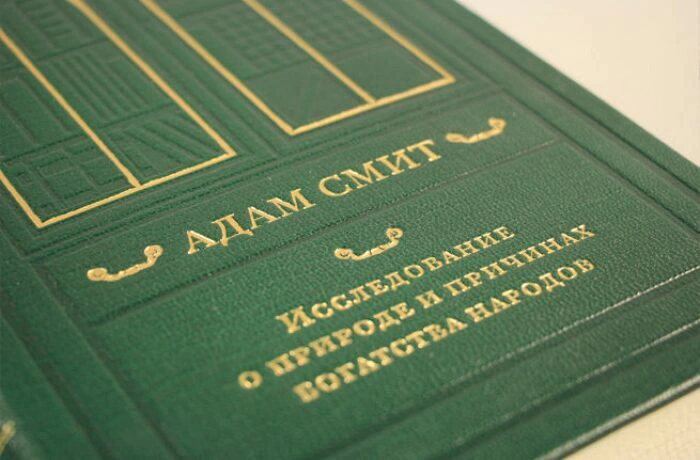The leather-bound book "A Study on the nature and causes of the Wealth of Nations" by Adam Smith