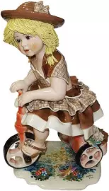 Statuette "Doll on a bicycle in a light brown dress"