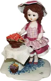 Statuteca "A doll standing at a table with flowers"