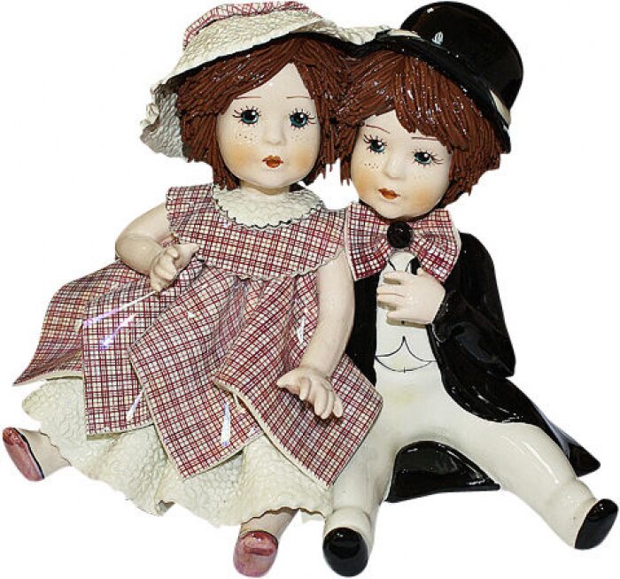 The statuette "A girl and a boy sitting" is multicolored