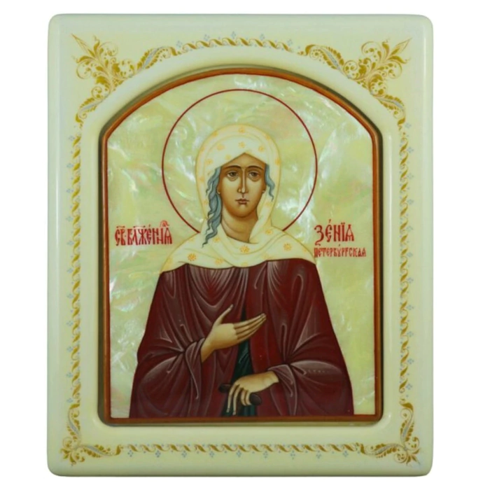 The icon with mother-of-pearl "Xenia of St. Petersburg" in a white frame with an ornament