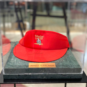 Cap-visor autographed by golfer Arnold Palmer, green marble