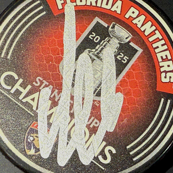 An autographed puck by hockey player Alexander Barkov
